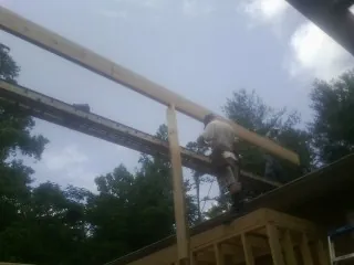 Carpenter setting a ridge beam over a new addition frame — Ice Dam Removal by Roofing Brothers in Poulsbo