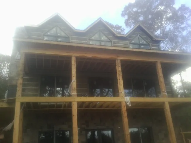 Dormers and porch framing on a large log home under construction — Roof Coating work by our crew in Poulsbo