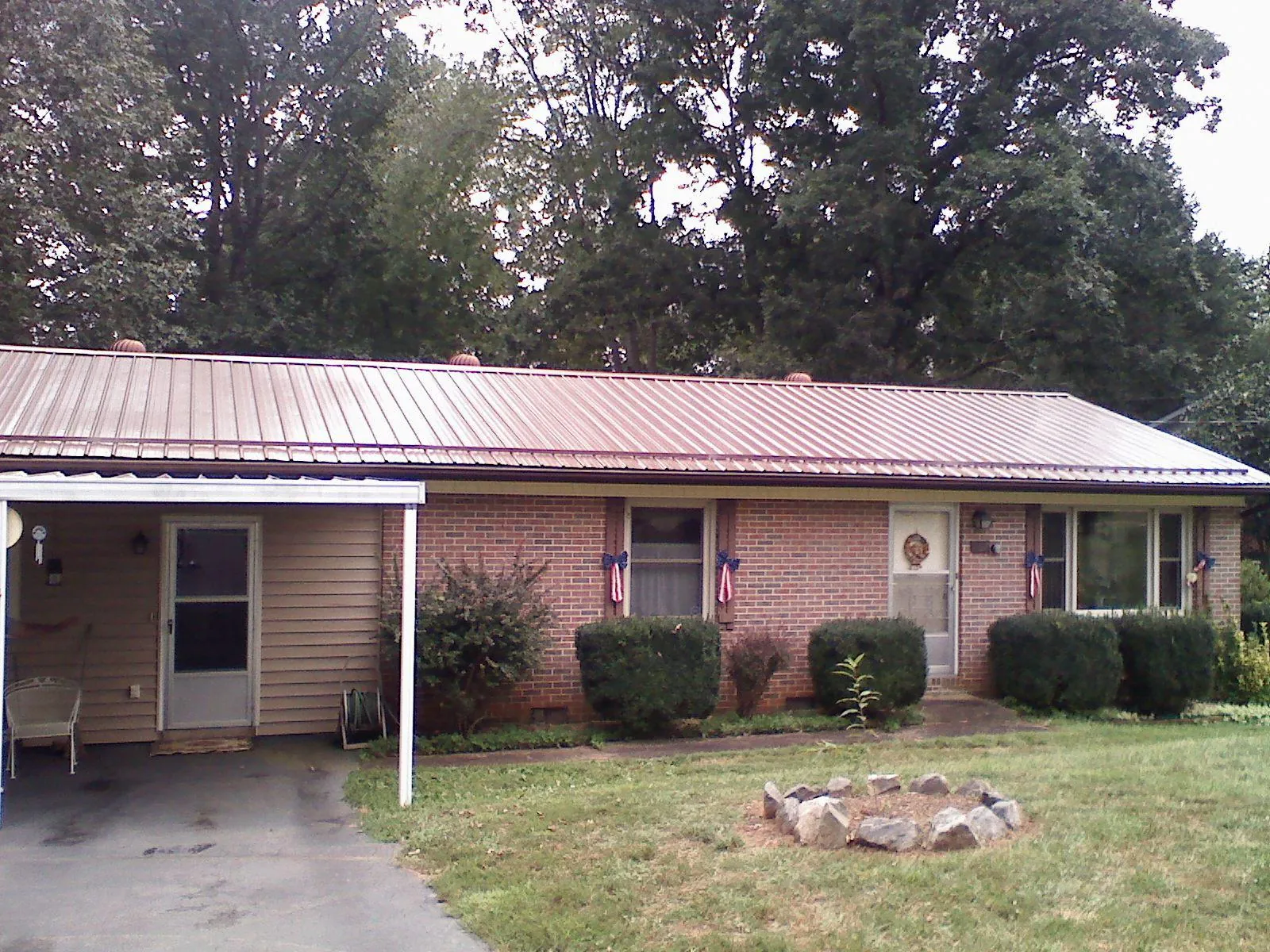 Bronze metal roof and carport on a brick ranch home — Roof Repair work by our crew in Poulsbo